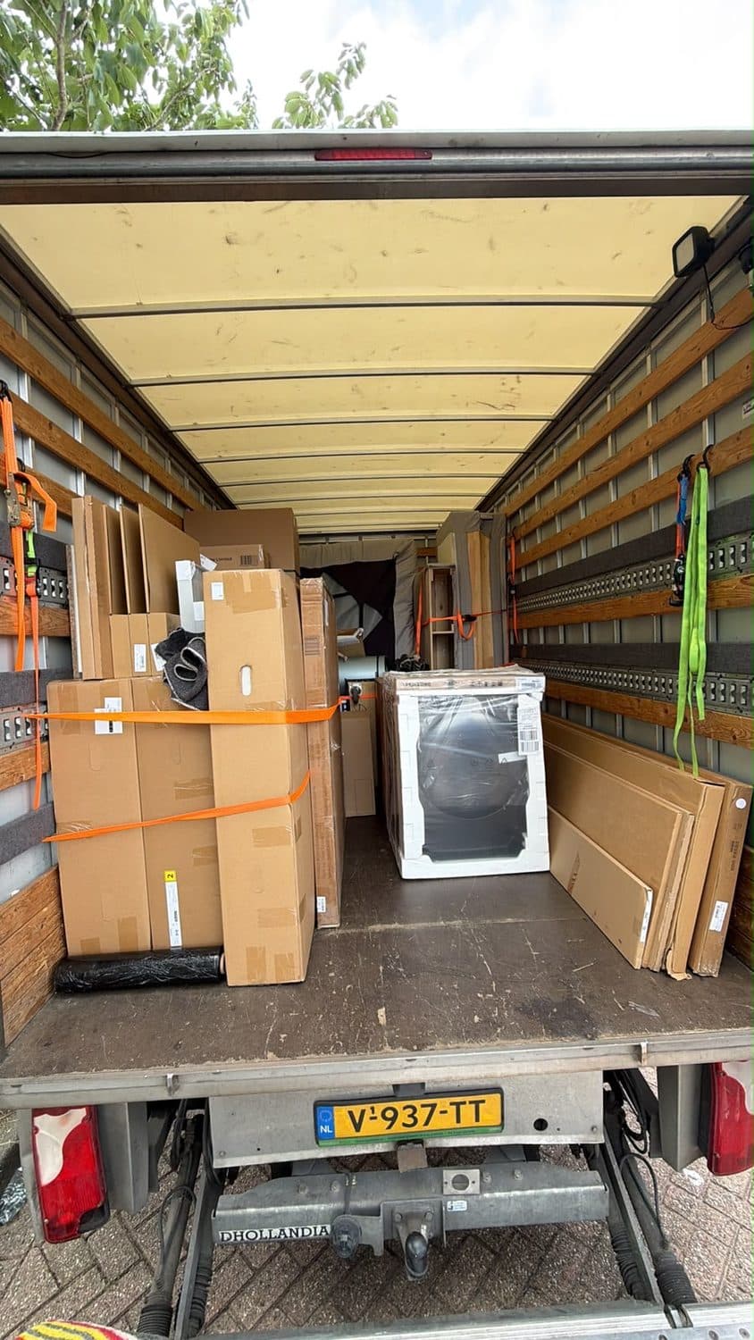 Volgeladen verhuiswagen met zorgvuldig vastgezette inboedel